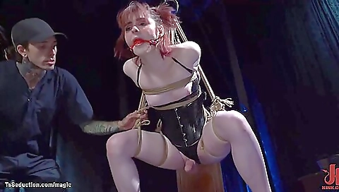 Sexy redhead in strappado bondage gagging for her husband